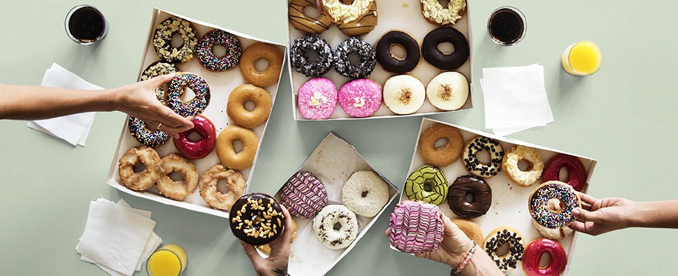hands chosing colorful donuts from paper boxes, many options and possibilities,